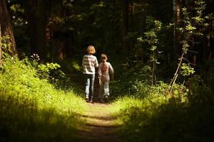jongen met een meisje gaan door het bos foto