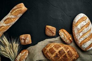 bakkerij - goud rustiek knapperig broden van brood en broodjes Aan zwart schoolbord achtergrond. foto