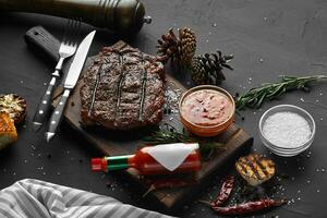 medium bijzonder gegrild steak biefstuk met maïs en knoflook Aan portie bord blok Aan zwart achtergrond foto