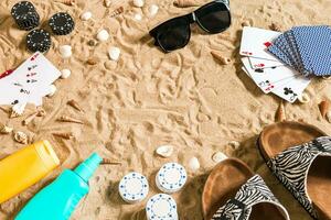 strandpoker. chips en kaarten Aan de zand. in de omgeving van de schelpen, zonnebril en omdraaien flopt. top visie foto