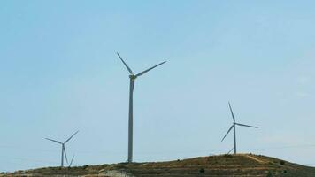 schot van een windmolen tegen een blauw lucht en groen heuvels, wind macht technologie. visie Aan turbine. Cyprus. foto