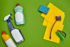 wasmiddelen en schoonmaak accessoires Aan een groen achtergrond. huishouding concept. foto