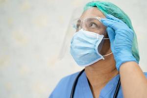 aziatische arts die gezichtsschild en ppe-pak draagt foto