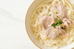 udon noedels met varkensvlees in heldere soep foto