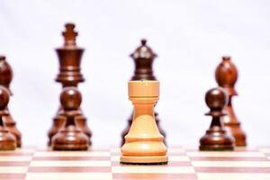 een schaak stuk is staand in voorkant van een groep van schaak stukken foto