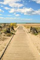 een houten loopbrug Leidt naar de strand foto