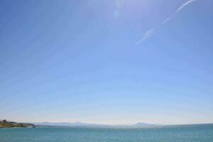 een strand met een blauw lucht en een Doorzichtig oceaan foto