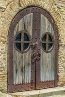 oud houten deur Aan een steen muur met ronde ramen foto