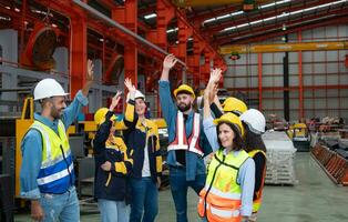 groep van fabriek arbeiders in harde hoeden met armen verheven vieren succes foto