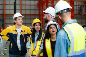 groep van fabriek arbeiders in harde hoeden met gewricht handen samen voor vieren succes foto