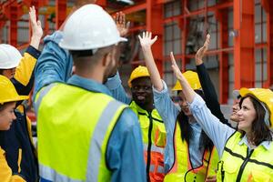 groep van fabriek arbeiders in harde hoeden met armen verheven vieren succes foto