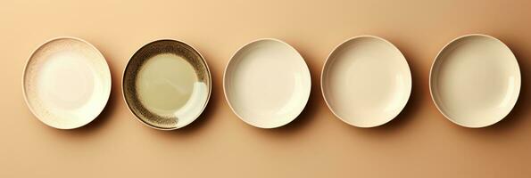 een chique reeks van minimalistisch porselein dining borden geïsoleerd Aan een taupe helling achtergrond foto