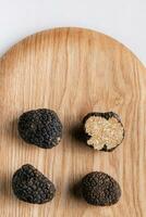 zwart truffel paddestoel dichtbij omhoog Aan houten bord foto