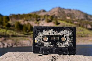een oud cassette zittend Aan top van een rots in de buurt een meer foto