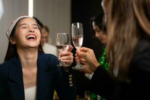 Aziatisch vrouw in de kerstman hoed gerinkel bril van Champagne Bij partij foto