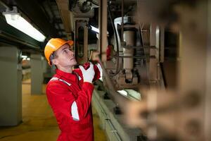 elektrisch trein ingenieur gebruik een walkietalkie naar inspecteren elektrisch trein machinerie volgens naar inspectie ronde na de elektrisch trein is geparkeerd in de elektrisch trein reparatie winkel foto