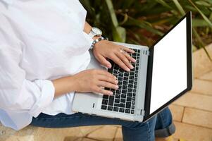 visie van bovenstaand van vrouw manager handen typen tekst Aan laptop toetsenbord. wit blanco mockup scherm met kopiëren advertentie ruimte foto