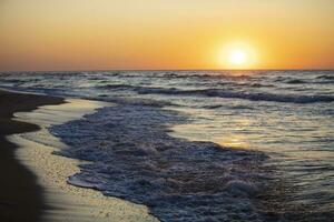 mooi zonsondergang over- de zee. rood zon en golven. foto