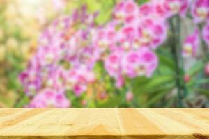 leeg hout tafel top met vervagen orchidee tuin achtergrond voor Product Scherm foto