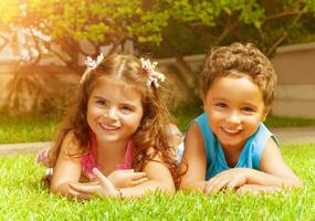 gelukkig kinderen Aan groen gras foto