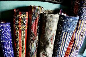 een rij van kleurrijk tapijten zijn bekleed omhoog Aan een muur foto