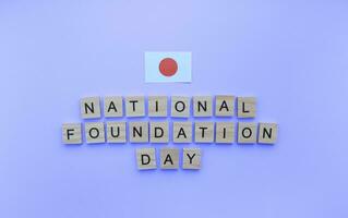 februari 11, nationaal fundament dag, vlag van Japan, minimalistisch banier met houten brieven Aan een blauw achtergrond foto
