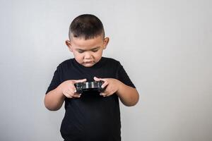 gelukkige jongen speel spelcomputer met een controller in studiofoto foto