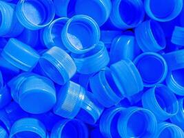 top visie blauw plastic fles doppen.recycling verzameling en productie verwerken plastic fles petten achtergrond foto