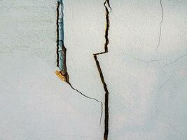 scheuren in de cement muur wit cement van gebouwen beschadigd door aardbevingen foto