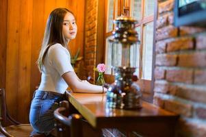 mooie vrouw zittend in een stoel in een café foto