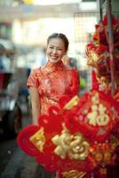 Aziatisch vrouw vervelend Chinese traditie kleren met Chinese bamboe ventilator glimlachen gezicht in yaowarat straat China stad- van Bangkok Thailand foto