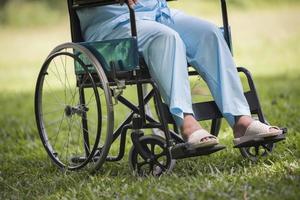 close-up eenzame oudere vrouw zittend op een rolstoel in de tuin foto