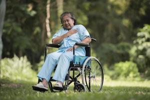 eenzame oudere vrouw zit verdrietig gevoel op rolstoel in de tuin foto