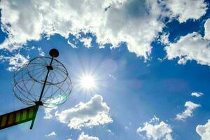 een metaal bal met een zon in de lucht foto