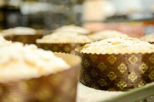 chef produceren panettone, terwijl lieviteren, toevoegen amandel suiker topping naar rauw zoet brood. foto