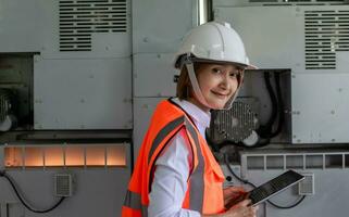 fabriek ingenieur vrouw vervelend harde hoed veiligheid hesje arbeider Bij werk industrieel gebruik makend van gegevens tablet onderzoeken kwaliteit project elektronisch en systeem productie, planning productie ontwikkeling machine foto