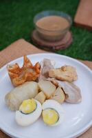 siomay, indonesisch traditioneel voedsel, gestoomd vis knoedel met pinda saus foto