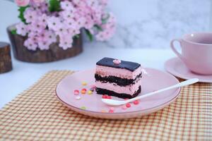 stuk van chocola taart Aan roze bord net zo een achtergrond foto