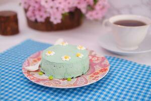 groen thee mousse taart met kop van koffie Aan de tafel. foto