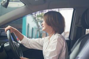 Dames zittend in de stoel en het rijden een auto naar Gaan werk, concentratie Aan het rijden voor veiligheid vervoer concept foto