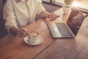 close-up van zakenvrouw die met laptop werkt en koffie drinkt