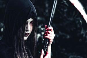 vrouwelijke demon heks met bloedige reaper foto