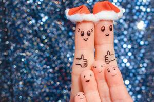 vinger kunst van groot familie viert kerstmis. concept van groep van mensen lachend in nieuw jaar hoeden. gelukkig paar tonen duimen omhoog. afgezwakt afbeelding. foto