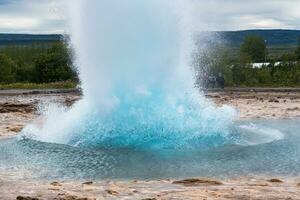 strokkur geiser uitbarsting, natuurlijk heet voorjaar pulserend in nationaal park foto