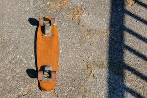 een skateboard is zittend Aan de grond De volgende naar een hek foto