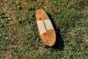een houten skateboard houdende Aan de gras foto