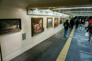 Osaka stad, jp, 2019 - interieur en loopbrug van Osaka metro met rij van kunst afbeelding Aan de muur. foto