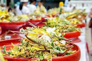 detailopname en gewassen hoop van geurig bloemen met wierook Aan rood houten dienbladen voor aanbidden de Boeddha in de Thais lanna wijden een boeket van bloemen naar aanbidden de Boeddha traditie. foto