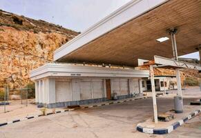 een leeg gas- station met een groot rots muur foto