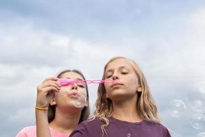 twee meisjes die zeepbellen blazen foto